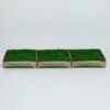 Three side-by-side trays of green artificial grass with Pipigrass branding on the boxes.